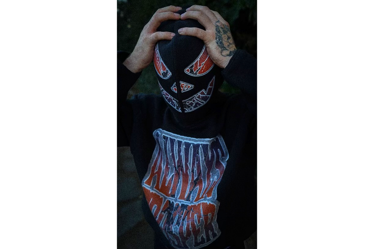Carved pumpkin face print on the hood of the Always Prosper Jack-O-Lantern hoodie, worn pulled over the face