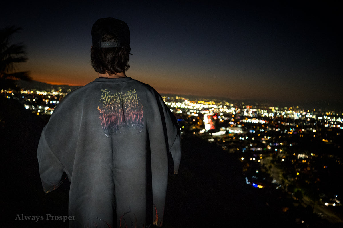 Back of the Through the Flames tee worn on a hillside above the city lights at night
