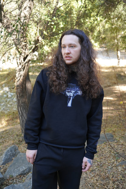 Model wearing the Always Prosper Trinity black crewneck with its cross graphic on the chest