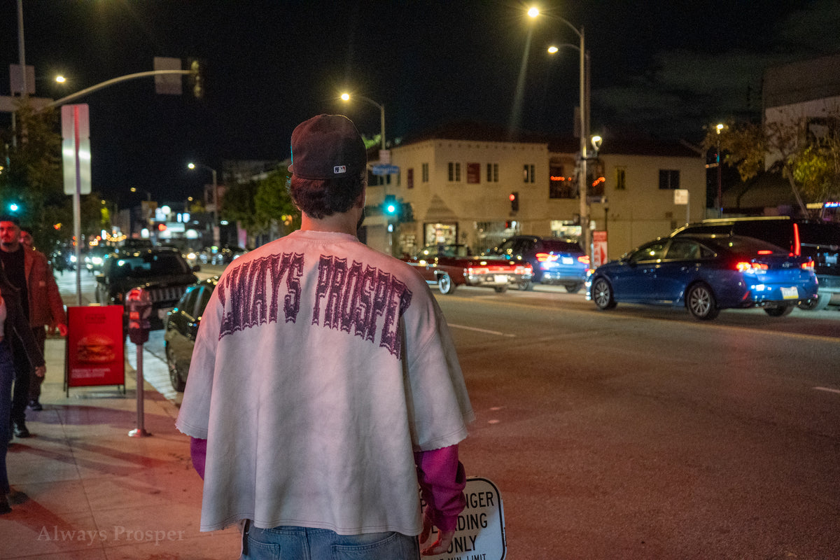 Arched Always Prosper back print on the AP University longsleeve, worn at a night intersection